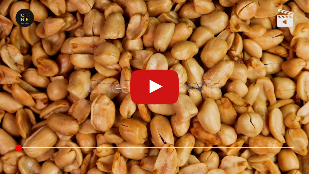 Top view of crispy fried garlic peanuts rotating 360 degrees on a black background.