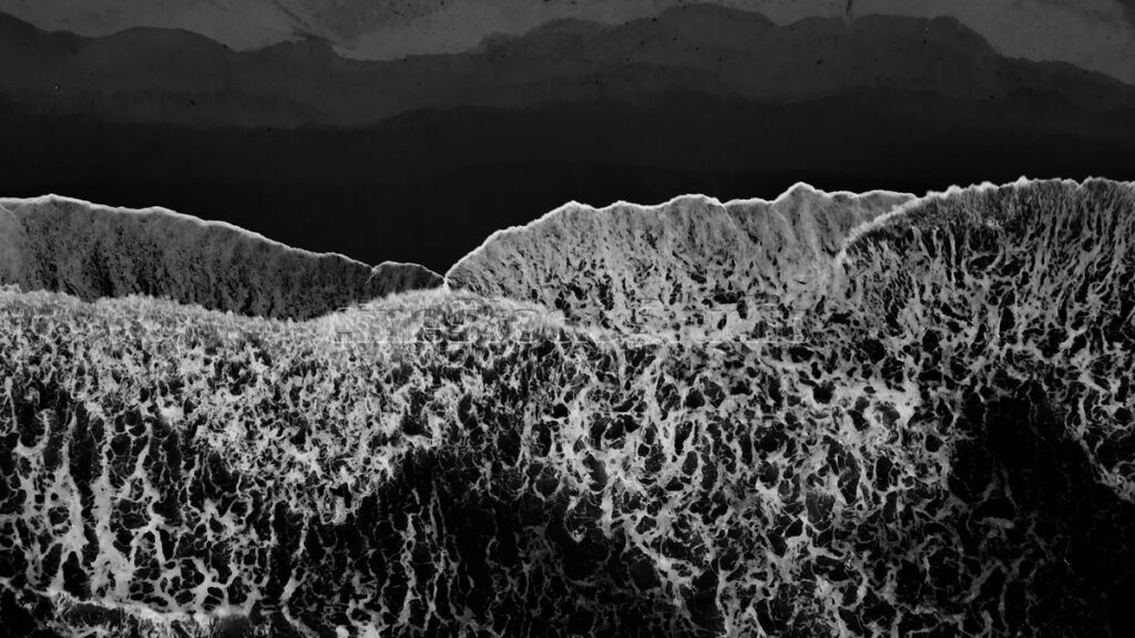 Top view Ocean Waves Crashing Against the Shoreline in black and white.