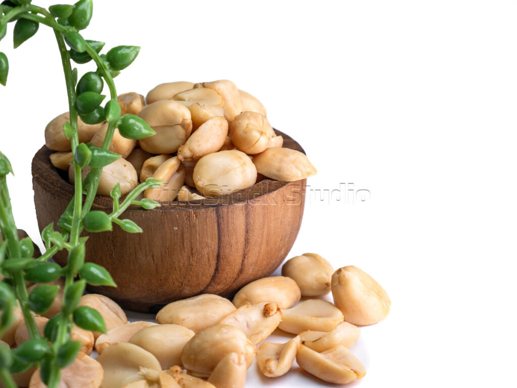 Roasted Peanuts in a Wooden Bowl with Green Leaves Decoration.