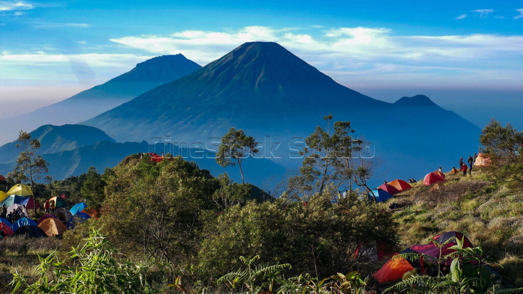The stunning view from the campsite on Mount Prau is filled with colorful tents of mountain climbers.