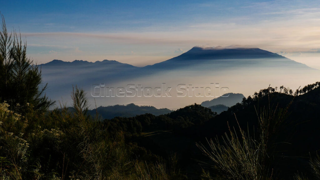 Panoramic silhouette of mountains covered in thin mist.
