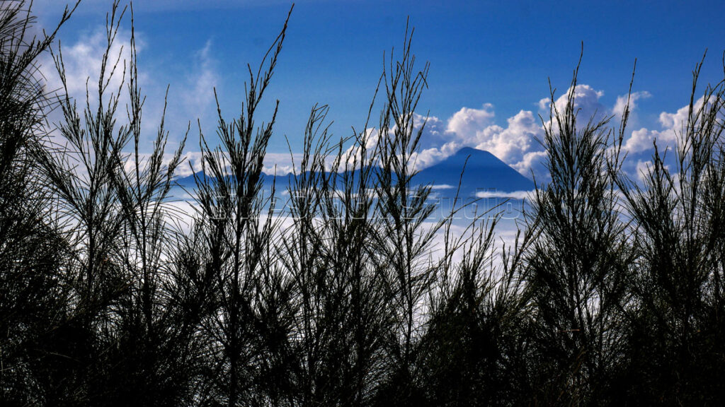 A majestic mountain view with thick white clouds.