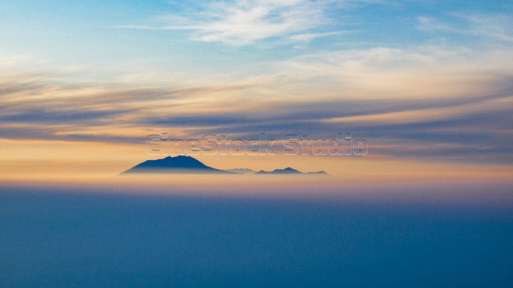 Silhouette of the mountain above the thick fog at sunrise.