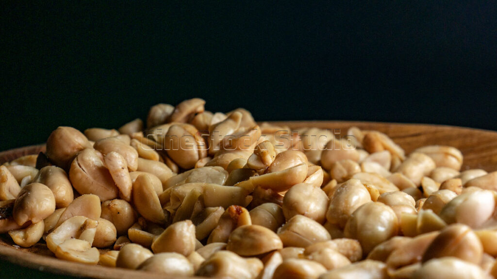 Crispy and tempting fried peanuts on a wooden plate.