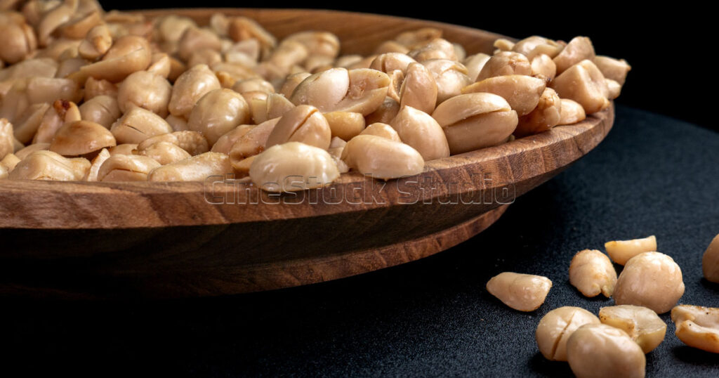 Roasted peeled peanuts in wooden plate.