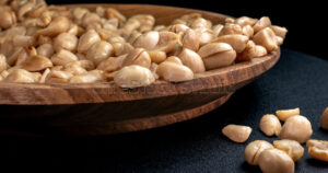 Roasted peeled peanuts in wooden plate.