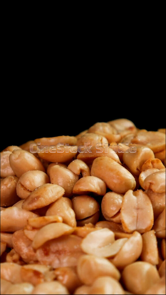 Portrait orientation video of savory fried peanuts rotating slowly to show texture.