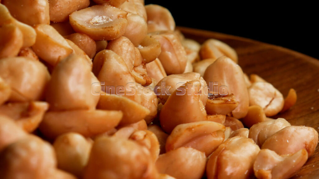 Close-up texture of salted fried peanuts in a seamless 360-degree rotating motion.