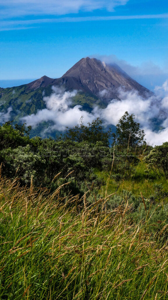 Vertical View of Mount Merapi with Thin Clouds and Blue Sky.