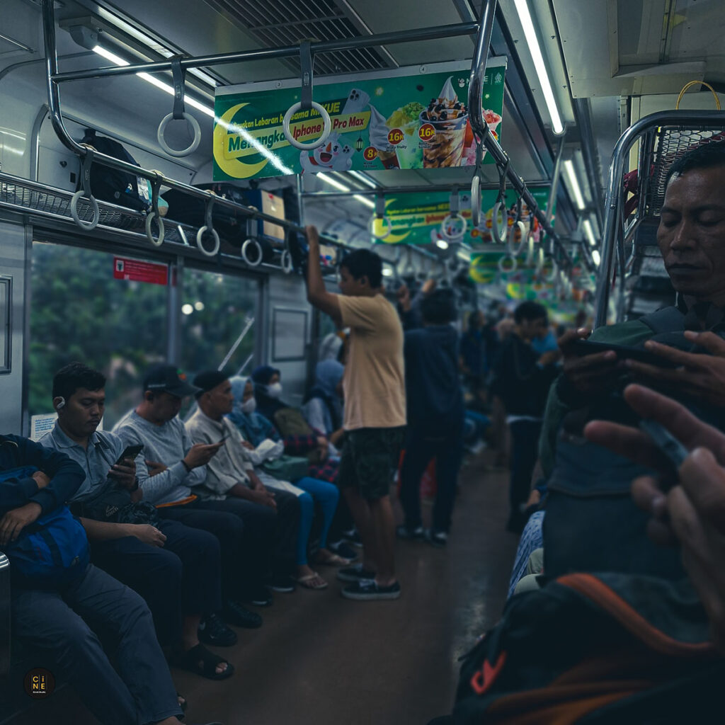 Para penumpang yang asyik dengan dunia digital mereka di dalam Commuter Line