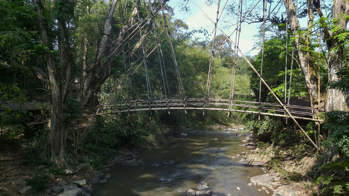 Side profile of Gajeboh Bamboo Bridge crossing over the river.
