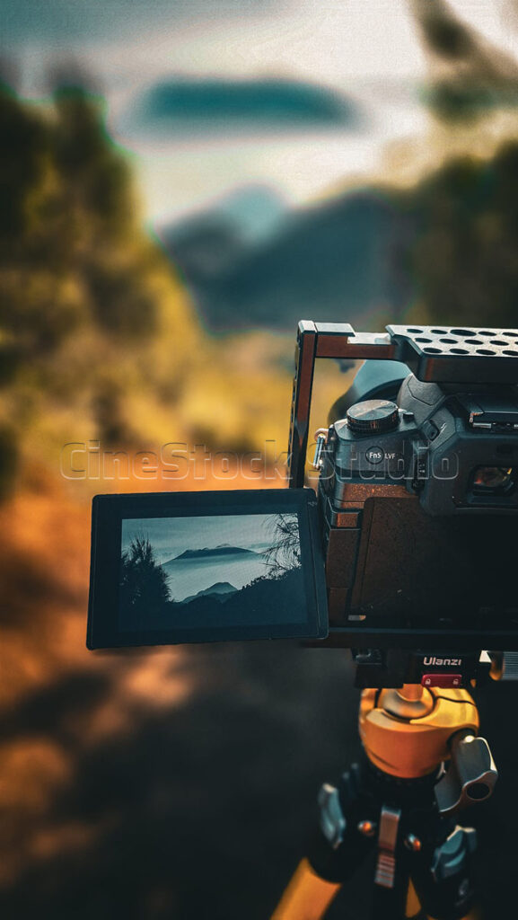 Close-up of a Lumix G85 camera screen showing a landscape preview with a beautiful cinematic bokeh background.