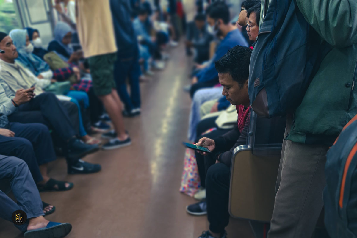 Standing passenger lost in their digital worlds during transit