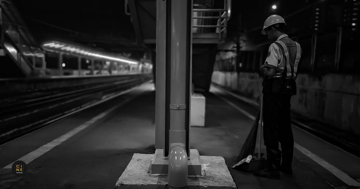 Early Morning Commute A cleaning staff member standing with a broom on a deserted Tanah Abang station platform.