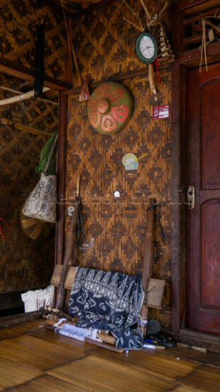 The authentic indoor atmosphere of a Baduy home featuring woven walls and daily life items. Interior of a Baduy house with bamboo walls and traditional artifacts