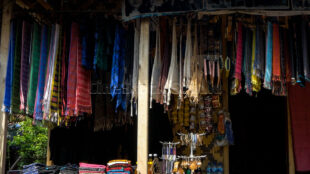 A vibrant collection of traditional Baduy textiles showcased at a local village workshop. Colorful Baduy woven fabrics hanging on a wooden display